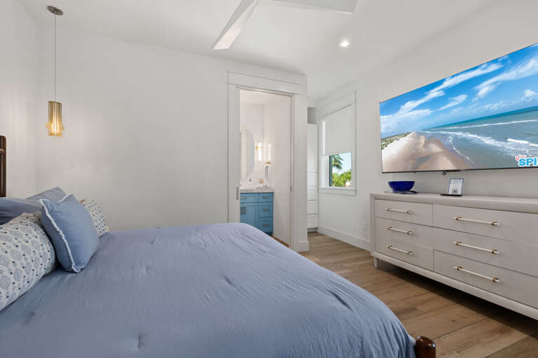 Unwind in the primary suite with a comfortable king bed, mounted TV, and plenty of space to relax.