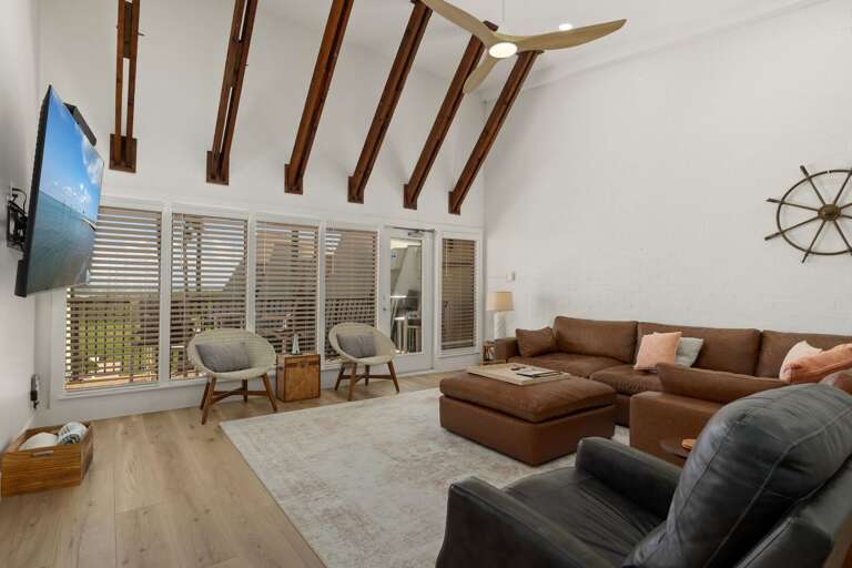 Enjoy the open living area with comfortable seating, vaulted ceilings, and sliding doors to the balcony.