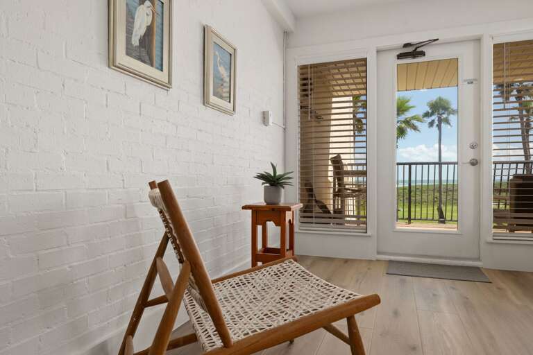 A cozy sitting area offers a peaceful spot to unwind while enjoying natural light and tropical views.