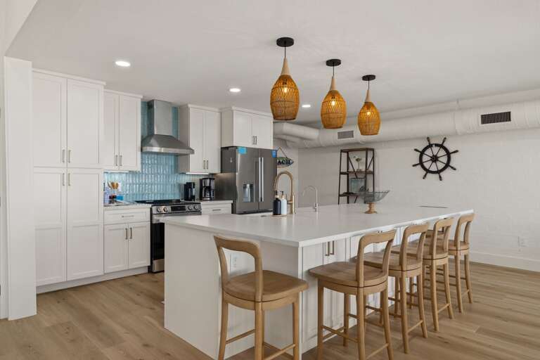The bright, updated kitchen features a spacious island, stainless steel appliances, and plenty of bar seating.