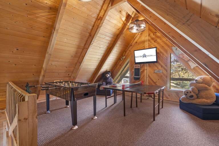 Attic Game Room With Foosball Table, TV, And Plush Seating