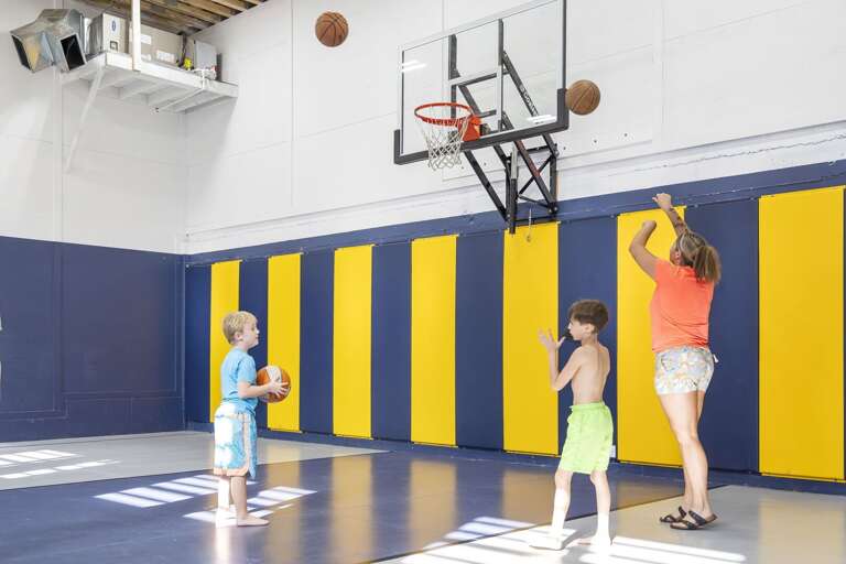 Family Playing Basketball Indoors, Bright Blue And Yellow Walls