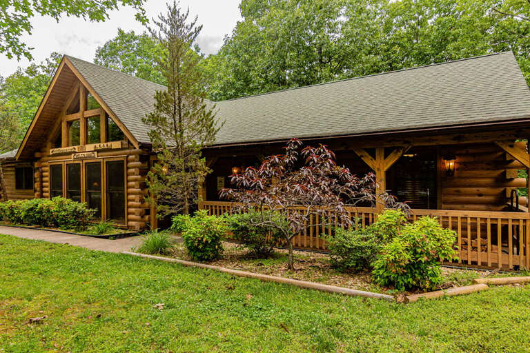 Log Cabin With Front Porch And Greenery