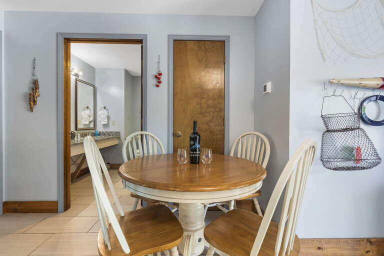 Interior Dining Area With Wooden Table And Chairs, Bottle On Table, Open Doorway