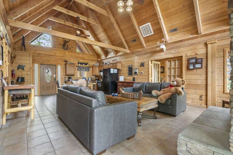 Wood-lined Room With Vaulted Ceiling, Plush Sofas, And Kitchen Space