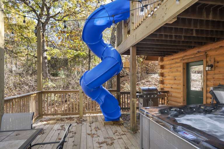Blue Slide Twists From Upper Deck To Wooden Backyard, Near Hot Tub