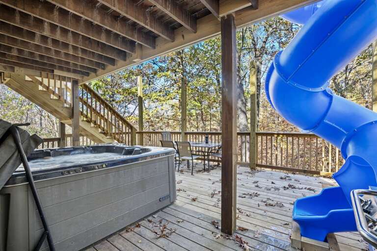Vacation Rental Deck With Hot Tub And Blue Slide Amidst Leafy Trees Vacation Rental Deck With Hot Tub And Blue Slide Amidst Leafy Trees