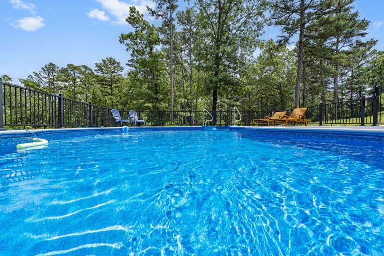 Swimming Pool With Deck Chairs And Trees
