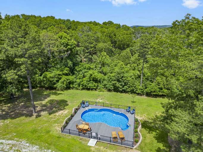 Aerial View Of A Blue Swimming Pool Surrounded By Trees