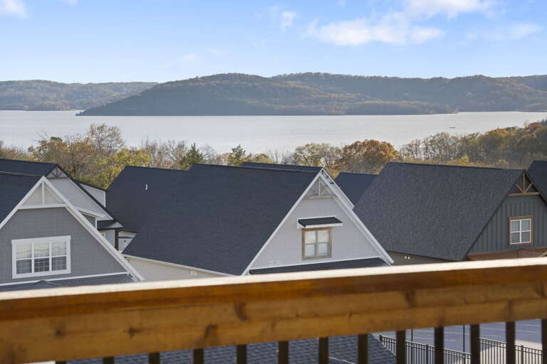 View Of Vacation Rentals Overlooking A Serene Lake With Distant Hills