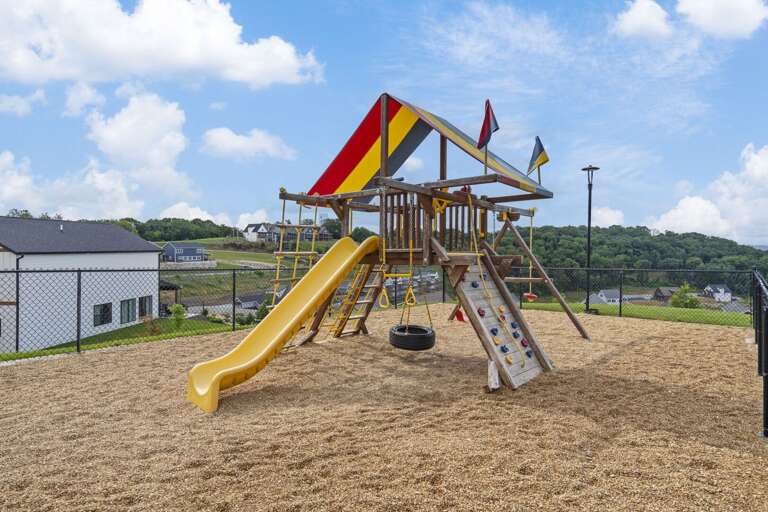 Playful Park Playground, Bright Banners Billowing, Slides And Swings Set Against Serene Sky