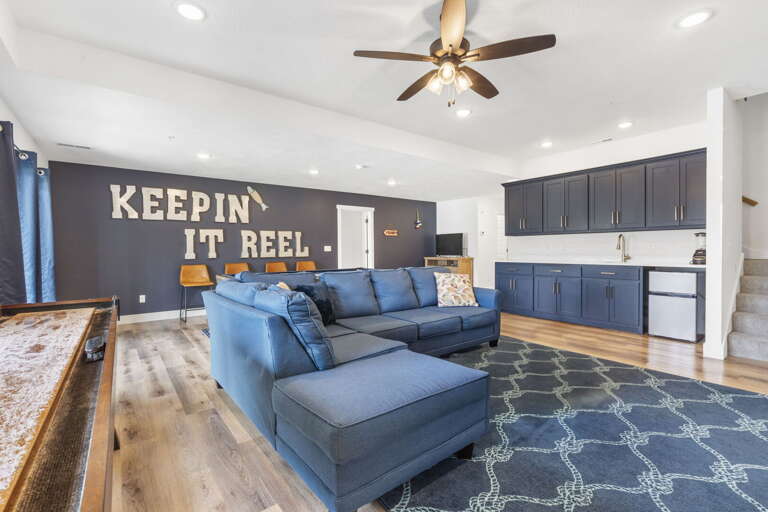 Spacious Room With Blue Sofa And Catchy Wall Message