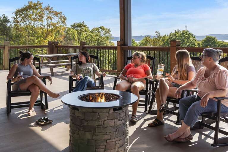Group Gathered Around A Gas Fire Pit On A Scenic Terrace