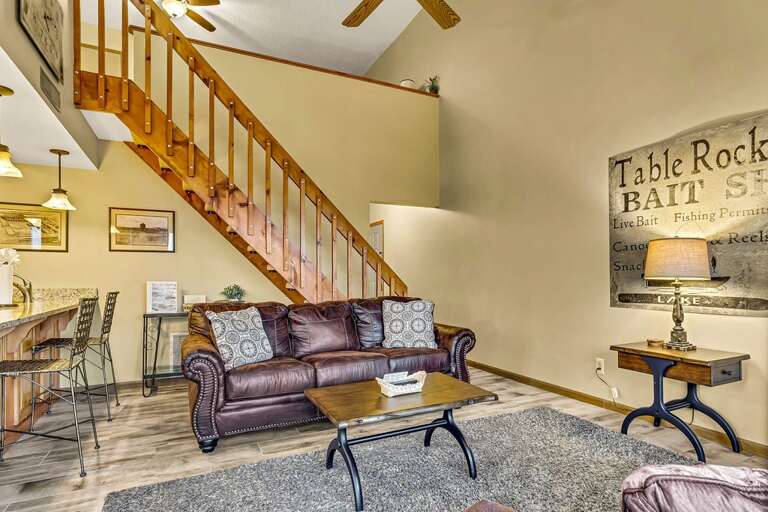 Living Room With Sofa, Stairs, And Wall Decor Living Room With Sofa, Stairs, And Wall Decor