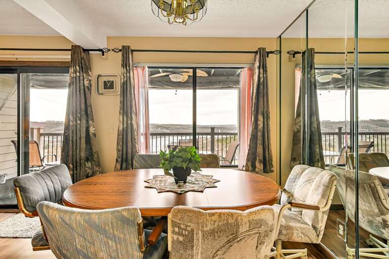 Dining Room With Wooden Table, Chairs, And Balcony Access