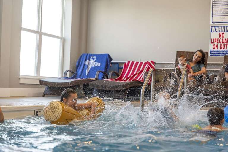 Indoor Pool Play, Splashing Swimmers, Serene Sunlight Streaming Through Window Indoor Pool Play, Splashing Swimmers, Serene Sunlight Streaming Through Window
