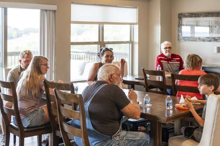 Family Gathering At A Dining Table, Chatting Cheerfully Family Gathering At A Dining Table, Chatting Cheerfully