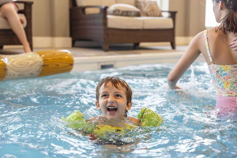Boy Beams Brightly, Bobbing Buoyantly In Blue Pool