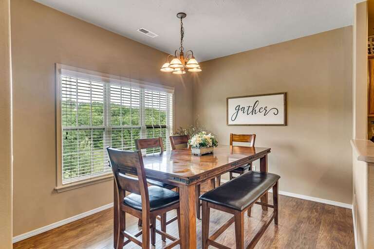 Dining Room With Wooden Table, Chairs, And Chandelier