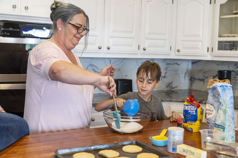 Woman And Child Whisking Batter In Bright Kitchen Setting