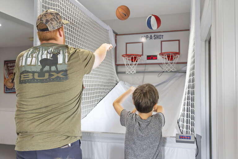 Man And Boy Shooting Basketball Indoors