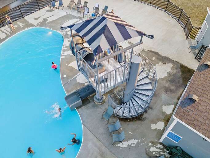 Outdoor Swimming Pool With Spiral Staircase And Guests Swimming