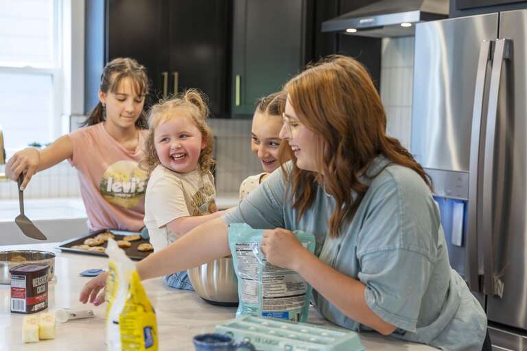Family Fun In Vacation Rental Kitchen Preparing Pancakes