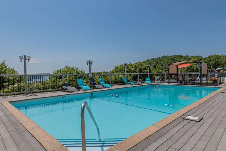 Outdoor Swimming Pool With Lounge Chairs And Trees In The Background Outdoor Swimming Pool With Lounge Chairs And Trees In The Background