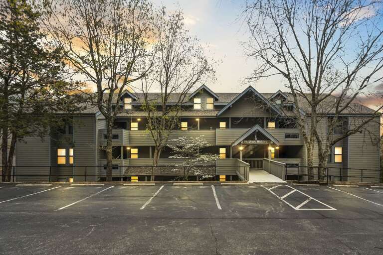 Multi-story Residential Building With Parking Lot At Dusk Multi-story Residential Building With Parking Lot At Dusk