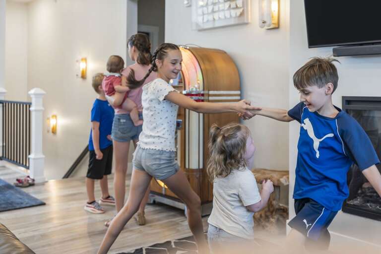 Children Playing Tag In A Spacious Vacation Rental Living Room