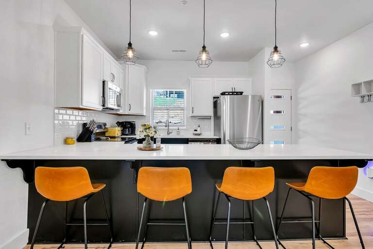 Kitchen Interior With Bar Stools And Pendant Lights