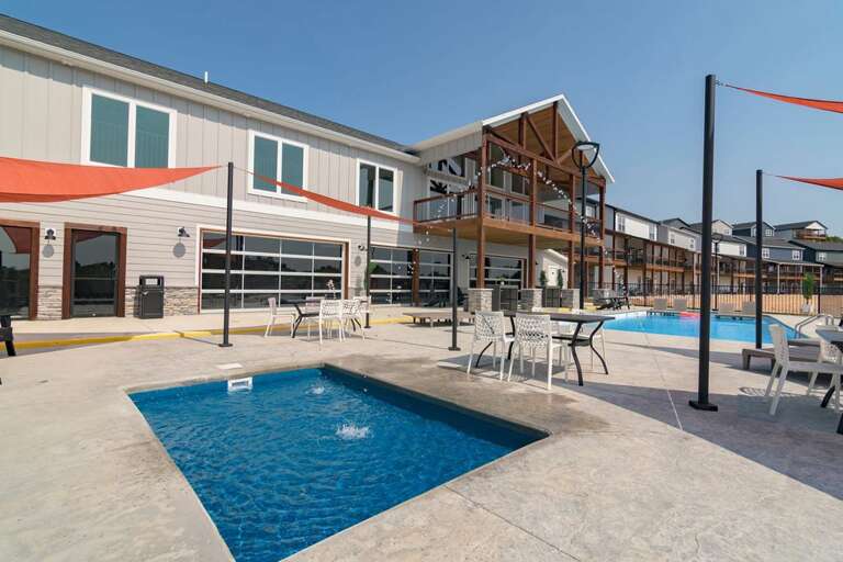 Outdoor Swimming Pool And Patio Area With Buildings In Background