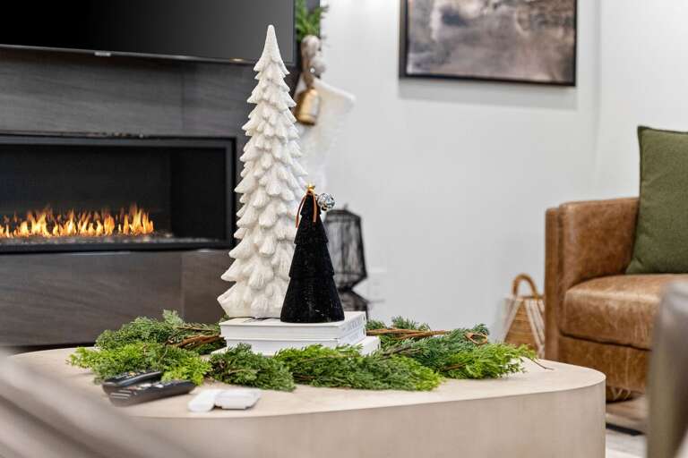 Living Space With Festive Decorations Featuring A Fireplace And Fir Figures