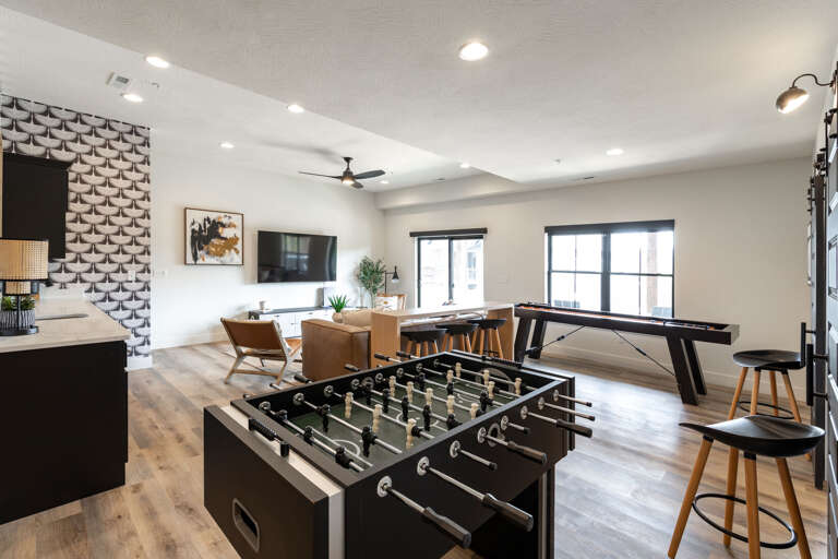 Interior Living Space With Foosball Table, Dining Area, And Kitchen