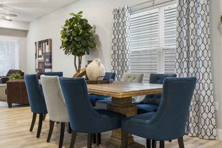 Dining Area In Vacation Rental With Blue Chairs And Wooden Table Dining Area In Vacation Rental With Blue Chairs And Wooden Table