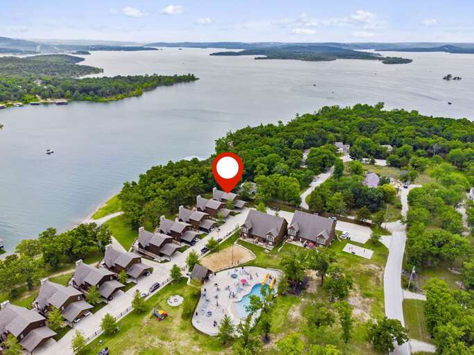 Aerial View Of Lakeside Lodging Complex With A Red Location Marker