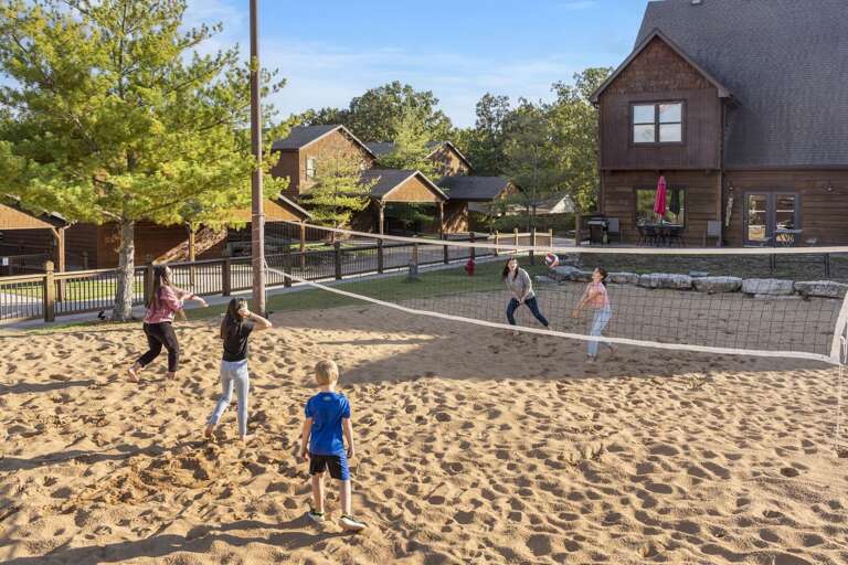 Guests Engage In A Volleyball Game At A Vacation Rental With Sand Court And Scenic Surroundings Guests Engage In A Volleyball Game At A Vacation Rental With Sand Court And Scenic Surroundings