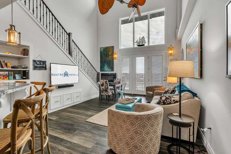 Interior Of A Vacation Rental Living Space With Staircase And High Ceiling