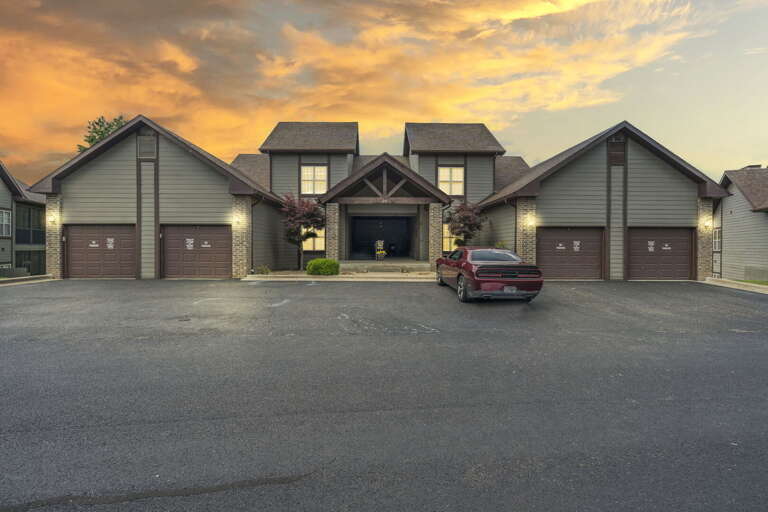 Suburban House At Dusk With Car Parked Outside