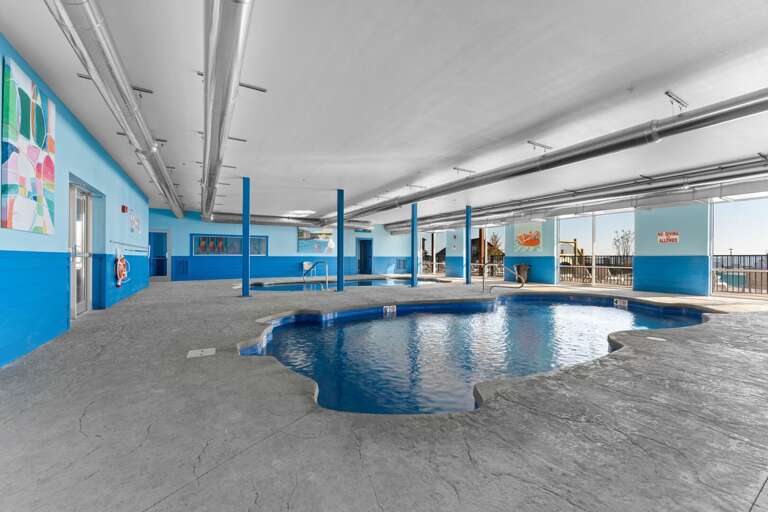 Indoor Pool With Blue Walls And Large Windows