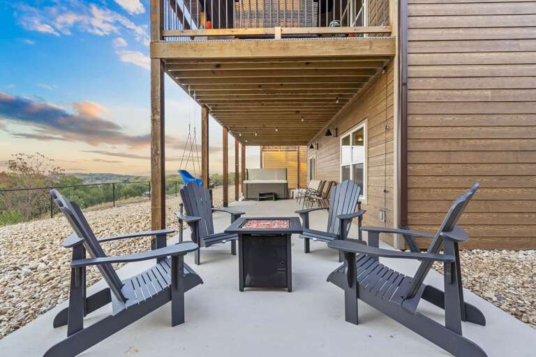 Outdoor Seating Area With Fire Pit And Chairs Under Building Overhang