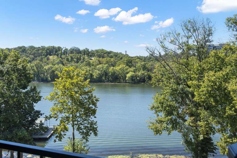 Serene Scene Of Still Lake Lined By Lush Trees Serene Scene Of Still Lake Lined By Lush Trees