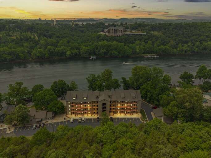 Riverfront Building At Dusk With Surrounding Trees