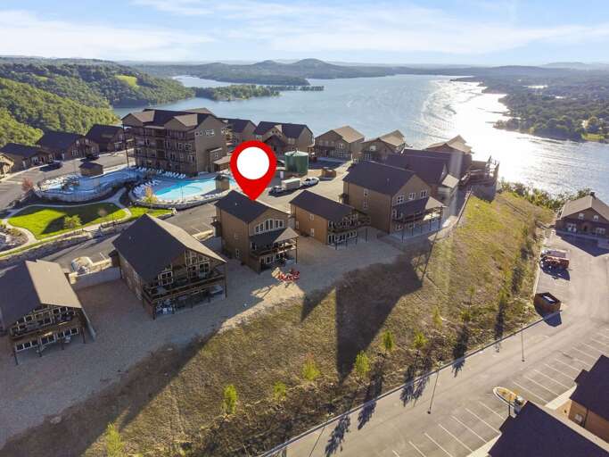 Aerial View Of Lakeside Buildings With Pool And Red Marker Icon
