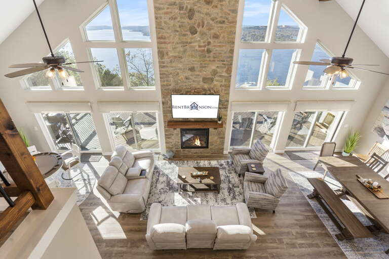 Spacious Living Room With High Ceiling And Stone Fireplace