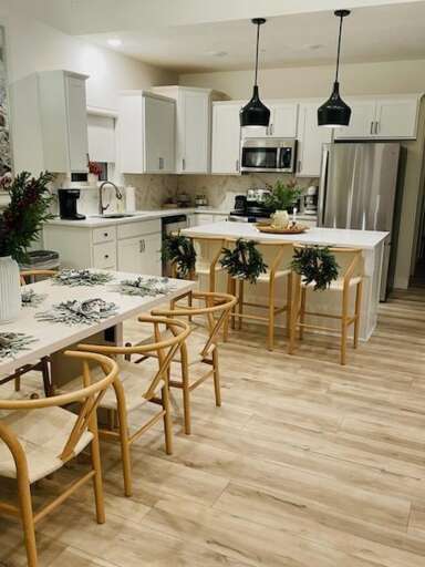 Bright, Breezy Vacation Rental Kitchen With Sleek Surfaces And Wooden Stools