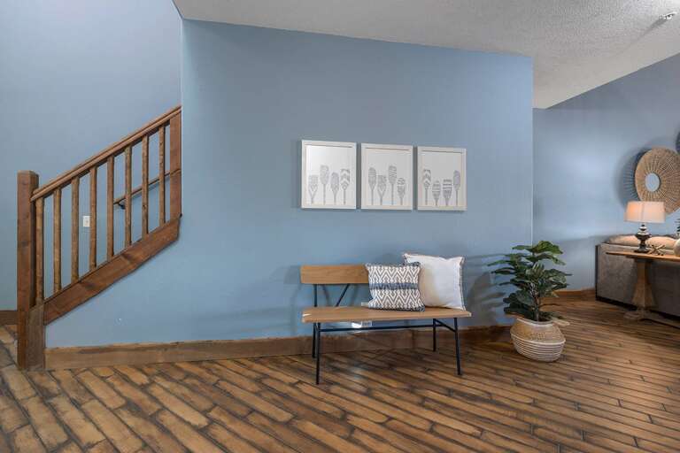 Interior Room With Blue Walls, Wooden Floor, Bench, And Staircase