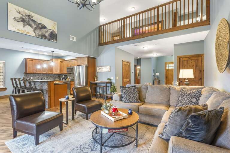 Living Room Interior With Furniture, Kitchen View, And Loft Railing Living Room Interior With Furniture, Kitchen View, And Loft Railing