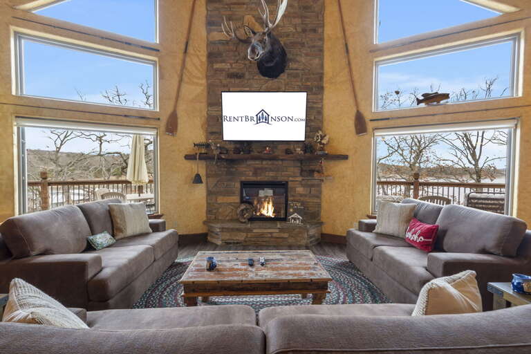 Rustic Living Room With Fireplace And Mounted Deer Head, Overlooking Outdoor Scenery