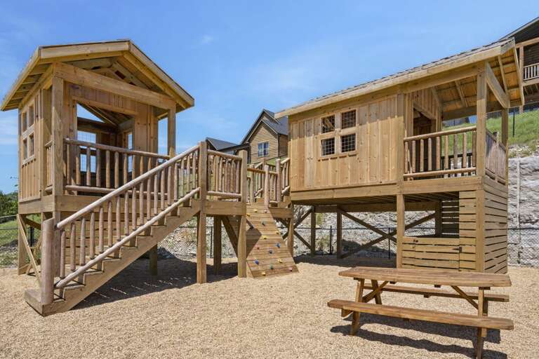 Wooden Playhouses With Stairs And A Picnic Table